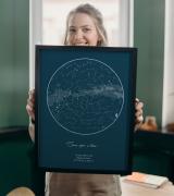 Una mujer sosteniendo un póster de mapa de estrellas